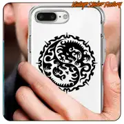 Autocollant circulaire avec deux dragons stylisés appliqué sur la coque transparente d’un téléphone