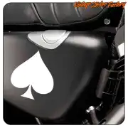 Vinilo blanco de as de picas colocado sobre el lateral negro de una motocicleta.