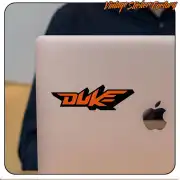 Two-tone orange and black Duke logo sticker applied to a laptop lid