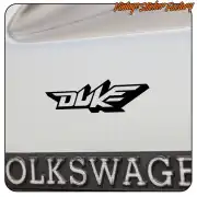 Schwarzes Duke-Logo am Heck eines Fahrzeugs neben einem Kennzeichen