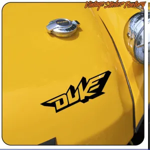 Logo Duke noir appliqué sur la surface jaune d’un véhicule