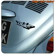 Logotipo Duke en negro aplicado sobre la carrocería gris de un vehículo