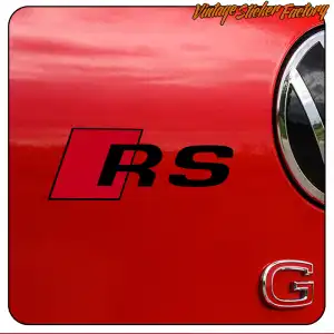 RS-Design auf roter Karosserie neben einem runden Volkswagen-Emblem angebracht