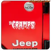 Adhésif blanc « THE CRAMPS » appliqué sur l’arrière d’une Jeep rouge