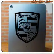 Schwarzes Porsche-Emblem auf der Rückseite eines Tablets angebracht