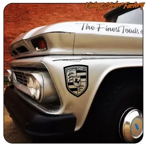 Kleines Porsche-Emblem an der Seite eines klassischen Fahrzeugs angebracht