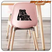 Texto negro «ARTIC MONKEYS» aplicado en el respaldo de una silla rosa