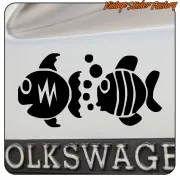 Two black fish applied to the rear of a vehicle, above a number plate