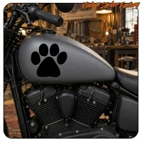 Pegatina de huella de perro negra sobre el depósito gris de una moto