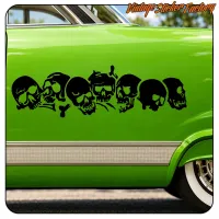 Detalle lateral de un coche clásico verde con una franja de siete calaveras negras
