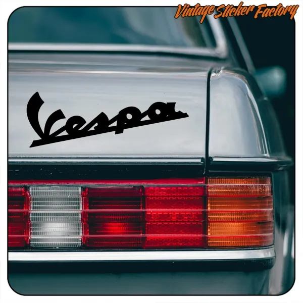 Black Vespa sticker on a vehicle rear, close-up of the rear light