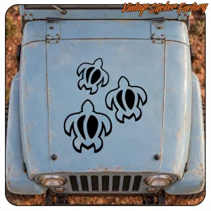 Drei haftende Tribal-Schildkröten auf der Motorhaube eines Oldtimers