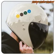 Adhesivos circulares de reciclaje colocados sobre la parte superior de un casco de motociclista