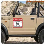 CAUTION AREA PATROLLED sticker placed on the door of a beige off-road vehicle