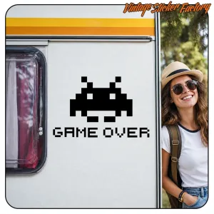Schwarzer «GAME OVER»-Aufkleber mit pixeligem Space Invader auf einem Wohnwagen