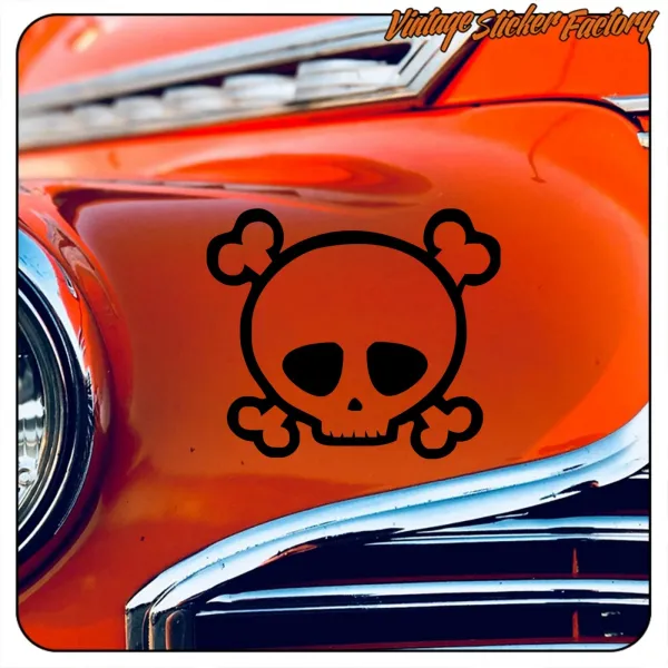 Tête de mort et os croisés noirs sur la carrosserie orange d’une voiture classique, vue alternative