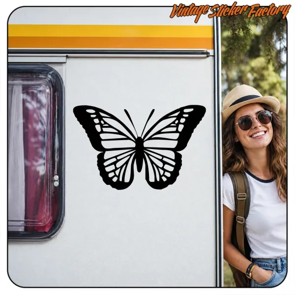 Schwarzer Klebeschmetterling auf einem Wohnmobil neben einer Reisenden