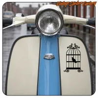 Cage noire avec un oiseau appliquée sur le carénage clair d’une moto bleue