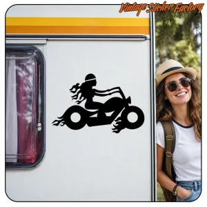 Silhouette noire d’un motard sur une moto posée sur le côté blanc d’une caravane
