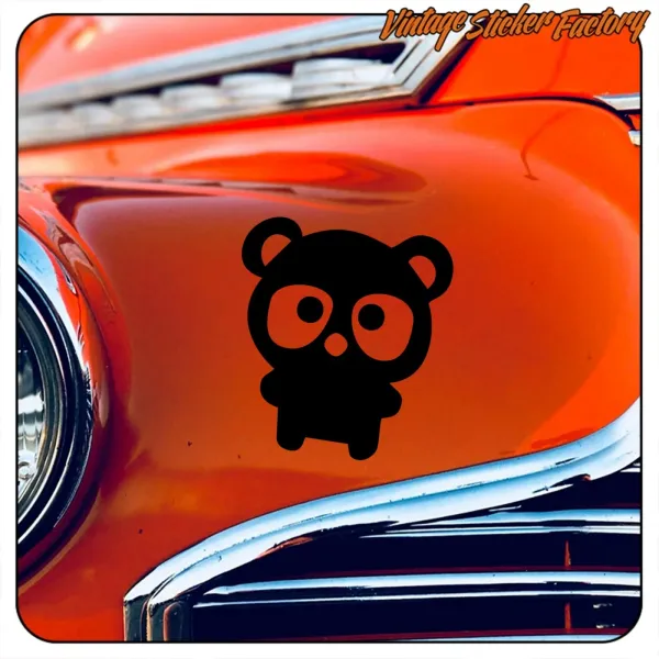 Black teddy bear applied to the orange bodywork of a classic car