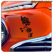 Diseño de dos rosas aplicado sobre la carrocería naranja de un automóvil clásico