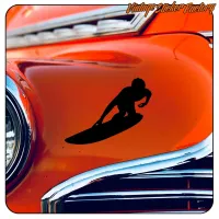 Silhouette noire d’un surfeur sur une planche sur la carrosserie orange d’une voiture classique