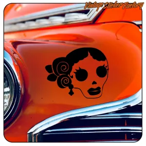 Crâne stylisé noir appliqué sur la carrosserie orange d’une voiture ancienne