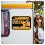 Autocollant avec texte en anglais appliqué sur le côté d’un camping-car, à côté d’une voyageuse
