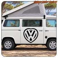 Furgoneta camper blanca con adhesivo de corazón y símbolo VW en la puerta lateral