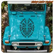 Schwarze Tiki-Maske auf der Motorhaube eines türkisfarbenen Fahrzeugs