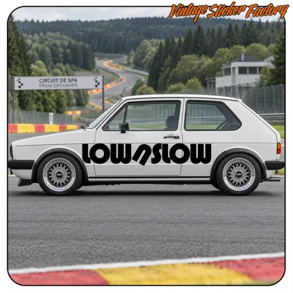 Voiture blanche avec le motif LOW N SLOW appliqué sur le côté, sur un circuit