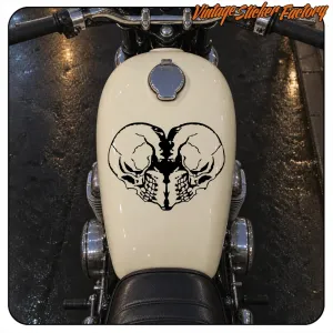 Two black skulls facing each other applied to a motorcycle fuel tank