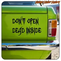 View of the “DON’T OPEN DEAD INSIDE” sticker placed on a green van