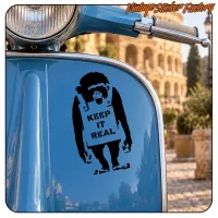 Détail de l’autocollant Keep It Real placé sur l’avant bleu d’un scooter