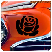 Rosa negra troquelada aplicada sobre la carrocería naranja de un coche clásico