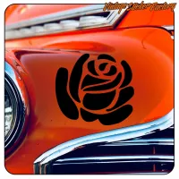 Detalle de la rosa negra aplicada en la carrocería naranja de un automóvil clásico