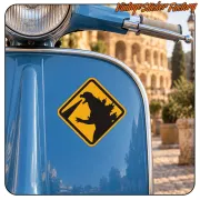 Pegatina CAUTION GODZILLA aplicada en el frontal azul de una scooter