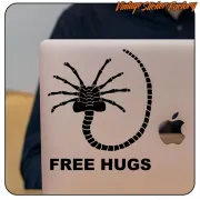 Adhesive with a spider-like creature and the text «FREE HUGS» applied to a laptop lid