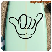 Sticker Shaka noir appliqué sur une planche de surf vert clair