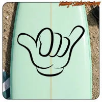 Diseño Shaka negro visto sobre una tabla de surf verde claro