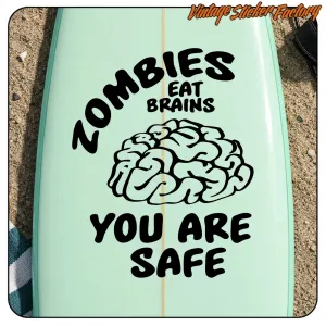 Pegatina «Zombies Eat Brains You Are Safe» aplicada sobre una tabla de surf verde claro