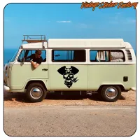 Furgoneta camper junto al mar con el diseño pirata aplicado en el lateral