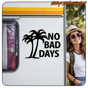 Black “NO BAD DAYS” sticker applied to a caravan beside a woman
