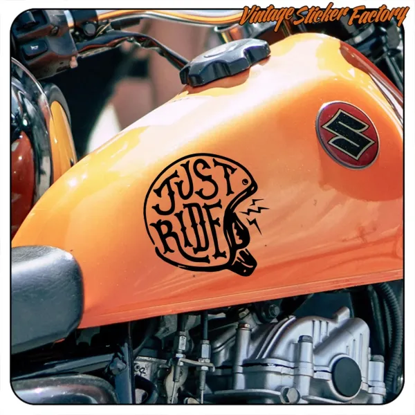 Ansicht des schwarzen Just Ride Motivs auf dem orangefarbenen Tank eines Motorrads