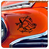 Diseño negro de La Muerte sobre monopatín aplicado en la carrocería de un coche clásico naranja