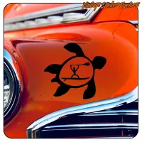 Tortuga negra practicando SUP aplicada en la carrocería de un coche clásico naranja