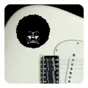 Design noir avec visage stylisé appliqué sur le corps d’une guitare électrique