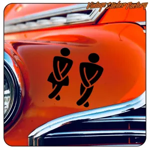 Two black toilet symbols applied to the orange bodywork of a vehicle