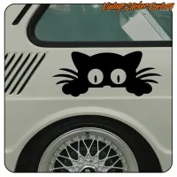 Detail des schwarzen Katzenaufklebers neben dem Rad eines weißen Fahrzeugs