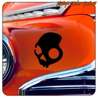 Detail of a black skull on the orange bodywork of a classic vehicle